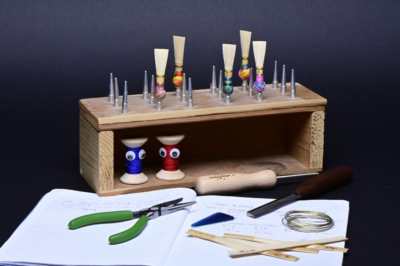 a cute reed making desk set up for an oboe and bassoon player, complete with cane, reeds, thread and scraping tools.